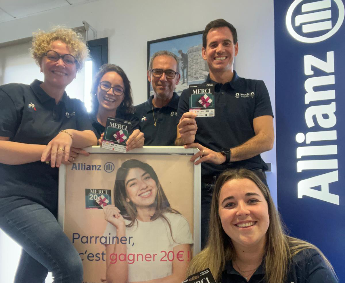 L'équipe de l'agence Allianz Vitré souriante devant le kakémono Allianz
